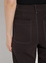 Load image into Gallery viewer, Crafted from 4-way stretch Knit Denim, these jeans boast a high-waisted, wide-leg cut with a concealed patented waistband, back patch pockets adorned with gunmetal studs, belt loops, and topstitching. The Erin High Waist Wide Leg Denim offers an extra-wide leg without side seams, presenting a cropped, ankle-length design with a raw-edge hem that can be easily shortened.