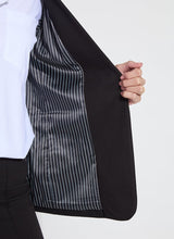 Load image into Gallery viewer, Close up of the interior lining of the black blazer with a white shirt underneath against a white background.