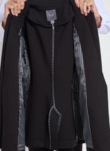 Load image into Gallery viewer, Woman holding the black blazer with a closeup of the interior of the blazer.