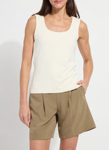 Load image into Gallery viewer, Woman wearing a macadamia-colored tank top and beige shorts on a plain background.
