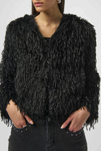 Load image into Gallery viewer, Woman wearing a black faux fur boxy jacket and black studded jeans against a white background.
