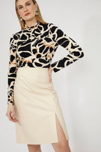 Load image into Gallery viewer, Woman wearing a patterned blouse and bone colored pencil skirt against a white background.
