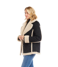 Load image into Gallery viewer, Woman wearing a black coat with cream shearling trim, black turtleneck and blue jeans against a white background.