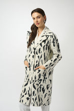 Load image into Gallery viewer, Woman wearing a white and black animal print coat with fur trim and white pants against a white background.