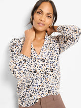 Load image into Gallery viewer, Woman wearing a cheetah print V-neck sweater and taupe pants against a white backdrop.