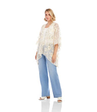 Load image into Gallery viewer, Woman wearing a floral gold and off-white kimono over a white top and blue jeans and white sandals standing against a white wall.