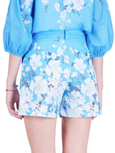 Load image into Gallery viewer, Person wearing a blue floral outfit with matching top and shorts on a white background.