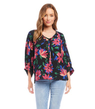 Load image into Gallery viewer, A vibrant floral print distinguishes this light-weight crepe top detailed with billowy blouson sleeves. A stunning top that will pair with a number of your favorite bottoms. Colors- Black, blue, pinks. Blouson sleeve. Split neck with ties. Floral print. Fabric -100% Rayon. Care- Dry clean.