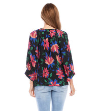 Load image into Gallery viewer, A vibrant floral print distinguishes this light-weight crepe top detailed with billowy blouson sleeves. A stunning top that will pair with a number of your favorite bottoms. Colors- Black, blue, pinks. Blouson sleeve. Split neck with ties. Floral print. Fabric -100% Rayon. Care- Dry clean.