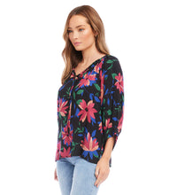 Load image into Gallery viewer, A vibrant floral print distinguishes this light-weight crepe top detailed with billowy blouson sleeves. A stunning top that will pair with a number of your favorite bottoms. Colors- Black, blue, pinks. Blouson sleeve. Split neck with ties. Floral print. Fabric -100% Rayon. Care- Dry clean.