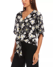 Load image into Gallery viewer, Woman wearing a black short sleeve tie top with white daisies and black pants on a white background.