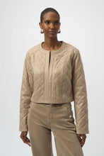 Load image into Gallery viewer, Woman wearing a warm taupe quilted jacket with silver embellishments and warm taupe jeans against a white background.