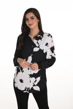 Load image into Gallery viewer, Woman wearing a black and white floral blouse and black leggings against a white background.
