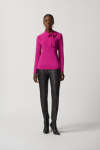 Load image into Gallery viewer, The Joseph Ribkoff long sleeve top features a slim silhouette, bow detail at the neckline, and an ultra-soft, stretchy fabric, allowing you to flaunt a feminine appearance. Ideal for wearing alone or for blending with a blazer, its design ensures a comfortable fit while elevating your look. Color- Opulence Fuchsia. Bow design detail at the neck. Keyhole neckline. Fabric -96% Polyester, 4% Spandex.