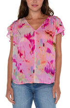 Load image into Gallery viewer, This woven tee is the perfect blouse to take you from season to season. Featuring a shirred back, v-neckline, and flirty petal sleeves, this top is a standout in vibrant colors.! Drawstring details at the shoulders create a fun and modern look.