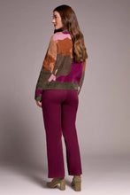 Load image into Gallery viewer, Woman wearing a colorful abstract print sweater, purple pants and olive suede heel shoes against a plain background.