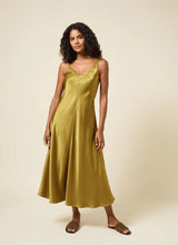 Load image into Gallery viewer, The Lyssé Gemma Silk Slip Dress is a luxurious and elegant piece designed for effortless sophistication. Crafted from high-quality polyester, this slip dress offers a smooth, lightweight, satin feel that drapes beautifully on the body. The Manzanilla color adds a rich, warm tone, making it perfect for both casual and formal occasions.