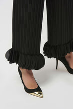 Load image into Gallery viewer, Black pleated pants with circle appliques on bottom hems and black and gold high-heeled shoes against a white background.