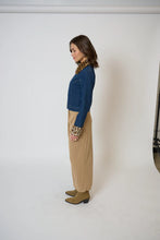 Load image into Gallery viewer, Woman wearing a blue denim jacket with leopard print collar and cuffs, beige pants, and tan boots against a white background.