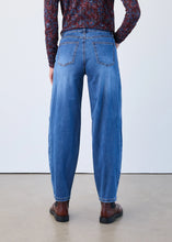 Load image into Gallery viewer, Model wearing blue jeans with a patterned shirt and brown shoes against a plain background.
