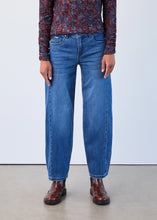 Load image into Gallery viewer, Model wearing blue jeans with a patterned shirt and brown shoes against a plain background.