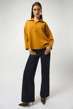 Load image into Gallery viewer, Woman wearing a mustard yellow sweater dark denim blue wide leg jeans and brown heels against a white background.