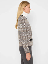 Load image into Gallery viewer, Woman wearing a black multicolored cardigan over a white turtleneck and grey pants against a white background.