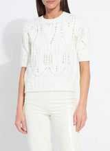 Load image into Gallery viewer, Woman wearing a white knit sweater with rhinestones and white pants against a plain background.