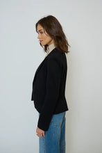 Load image into Gallery viewer, Woman wearing a black blazer with beige dickey and blue jeans against a white background.