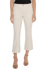 Load image into Gallery viewer, Woman wearing tan crop flare denim, black top and brown sandals against a white background.