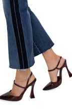 Load image into Gallery viewer, Our Hannah Crop Flare combines vintage inspiration with contemporary detailing, boasting a velvet trim for a modernized look. The cut hem of the medium washed denim elongates the silhouette while elevating the style. Make a statement and match it with the coordinating Denim Jacket for a complete ensemble. Color- Gilmore; dark blue with fading. 27” Inseam. Mid-rise. Velvet trim down the leg. Set-in waistband with belt loops. 5-Pocket styling details. Zip-fly and single logo button closure.