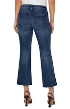 Load image into Gallery viewer, Our Hannah Crop Flare combines vintage inspiration with contemporary detailing, boasting a velvet trim for a modernized look. The cut hem of the medium washed denim elongates the silhouette while elevating the style. Make a statement and match it with the coordinating Denim Jacket for a complete ensemble. Color- Gilmore; dark blue with fading. 27” Inseam. Mid-rise. Velvet trim down the leg. Set-in waistband with belt loops. 5-Pocket styling details. Zip-fly and single logo button closure.