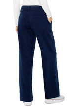 Load image into Gallery viewer, Model wearing navy blue jeans, white top and white sneakers against a white background.