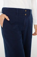 Load image into Gallery viewer, Close up of model wearing navy blue jeans against a white background.