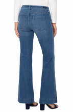 Load image into Gallery viewer, Model wearing blue jeans with side striping, white top and black heels against a white background.