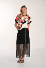 Load image into Gallery viewer, Woman wearing a floral top, long black skirt with mesh and black sandals on a white background.