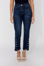 Load image into Gallery viewer, Model wearing dark blue jeans with decorative crystal buttons and beige sandals on a white background.