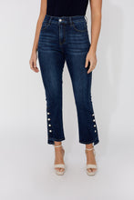 Load image into Gallery viewer, Model wearing dark blue jeans with decorative crystal buttons and beige sandals on a white background.