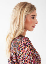 Load image into Gallery viewer, This long-sleeve top offers a unique mixed print design, creating an eye-catching aesthetic. Its versatile style allows for the sleeves to be worn both up or down, with a tab detail for a more relaxed look. Colors- Indi Abstract; Black, burgundy, light blue, white, orange, lilac. Button down. Roll Up Tab Sleeve. Mixed print. No stretch fabrication. Smocking detail on back.