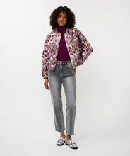 Load image into Gallery viewer, Woman wearing a mosaic patterned jacket over a maroon top, grey jeans and silver shoes against a white background.