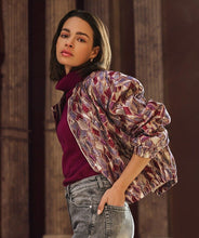 Load image into Gallery viewer, Woman wearing a mosaic patterned jacket over a maroon top with gray jeans against a wooden background.