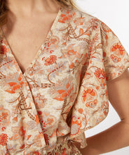 Load image into Gallery viewer, A breathtaking blend of orange, brown and red floral motifs on a pastel peach backdrop define the fashionable aura of the Tinslee jumpsuit. Delicate gold accents adorn the piece, accentuating the visual appeal of the design. For added drama, it features ruffled sleeves and an elasticized waist with tassels to give it a captivating, effortless style. Color- Orange, brown, red, pastel peach, gold. One piece. Elasticized waist with tassels. V-neck. Ruffle sleeves. Fabric- 100% Polyester.