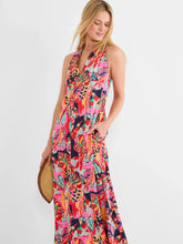 Load image into Gallery viewer, Woman carrying a straw purse and wearing a bright red multicolor sleeveless dress against a white background.
