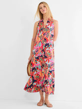Load image into Gallery viewer, Woman carrying a straw purse and wearing a bright red multicolor sleeveless dress against a white background.