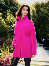 Load image into Gallery viewer, A woman wearing a bright fuchsia pink eyelash knit jacket with a collar, button-down front, and functional pockets.