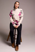 Load image into Gallery viewer, Woman sitting on a stool wearing a pink and black floral sweater, black pants and brown boots.