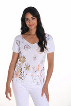 Load image into Gallery viewer, This Frank Lyman short sleeve knit top brings breezy charm to your wardrobe with a painterly floral print in pastels and foils and flattering V-neckline. Its lightweight knit drapes beautifully, creating a silhouette that feels both effortless and elevated—perfect for warm days when style still matters.
