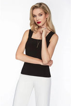 Load image into Gallery viewer, Woman wearing a black camisole tank and white pants on a white background.