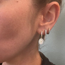 Load image into Gallery viewer, Close up of a model wearing multiple gold and crystal huggie earrings.