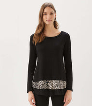 Load image into Gallery viewer, A woman modeling a black long-sleeve knit top with a leopard-print patterned hem, set against a plain light gray studio background.